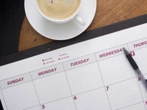 Time management using Open calendar with pen and coffee